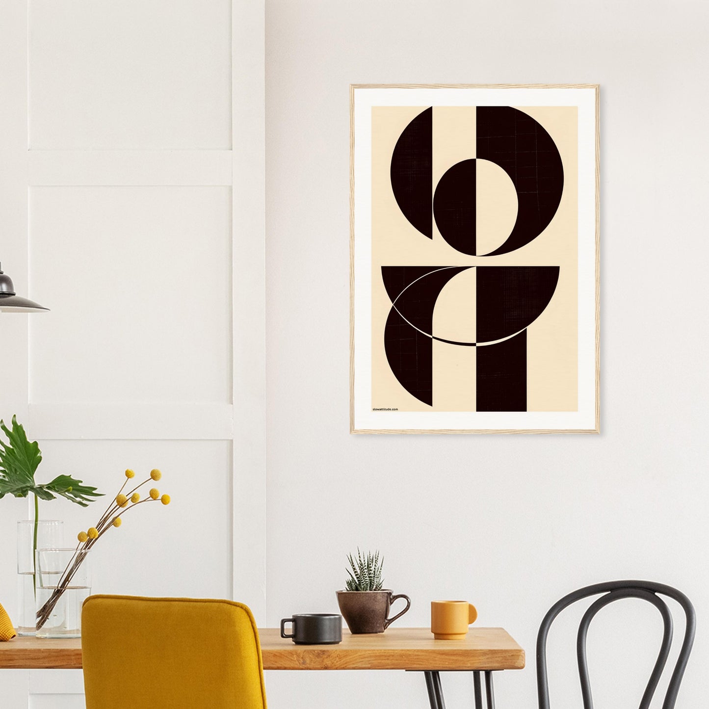 Abstract art print on a wall above a wooden table with chairs.