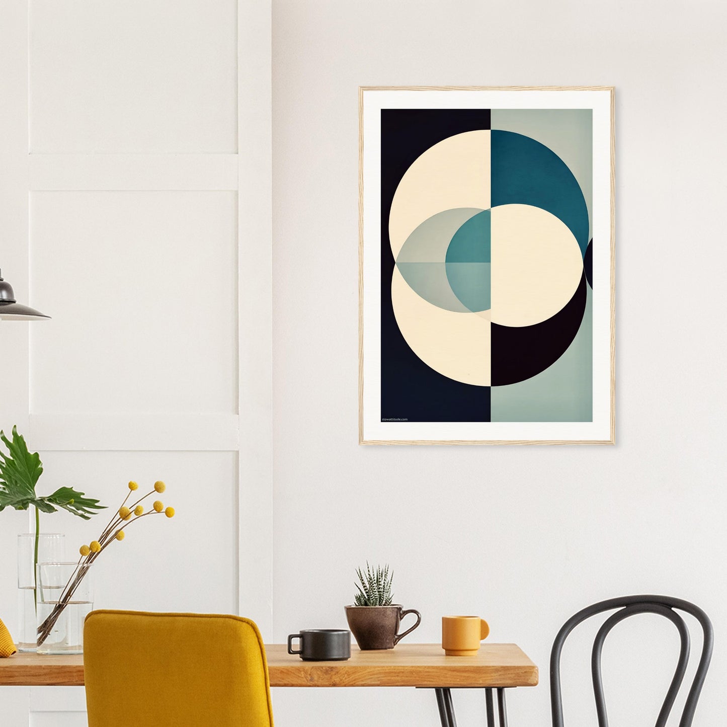 Abstract art print on a wall above a wooden table with chairs.