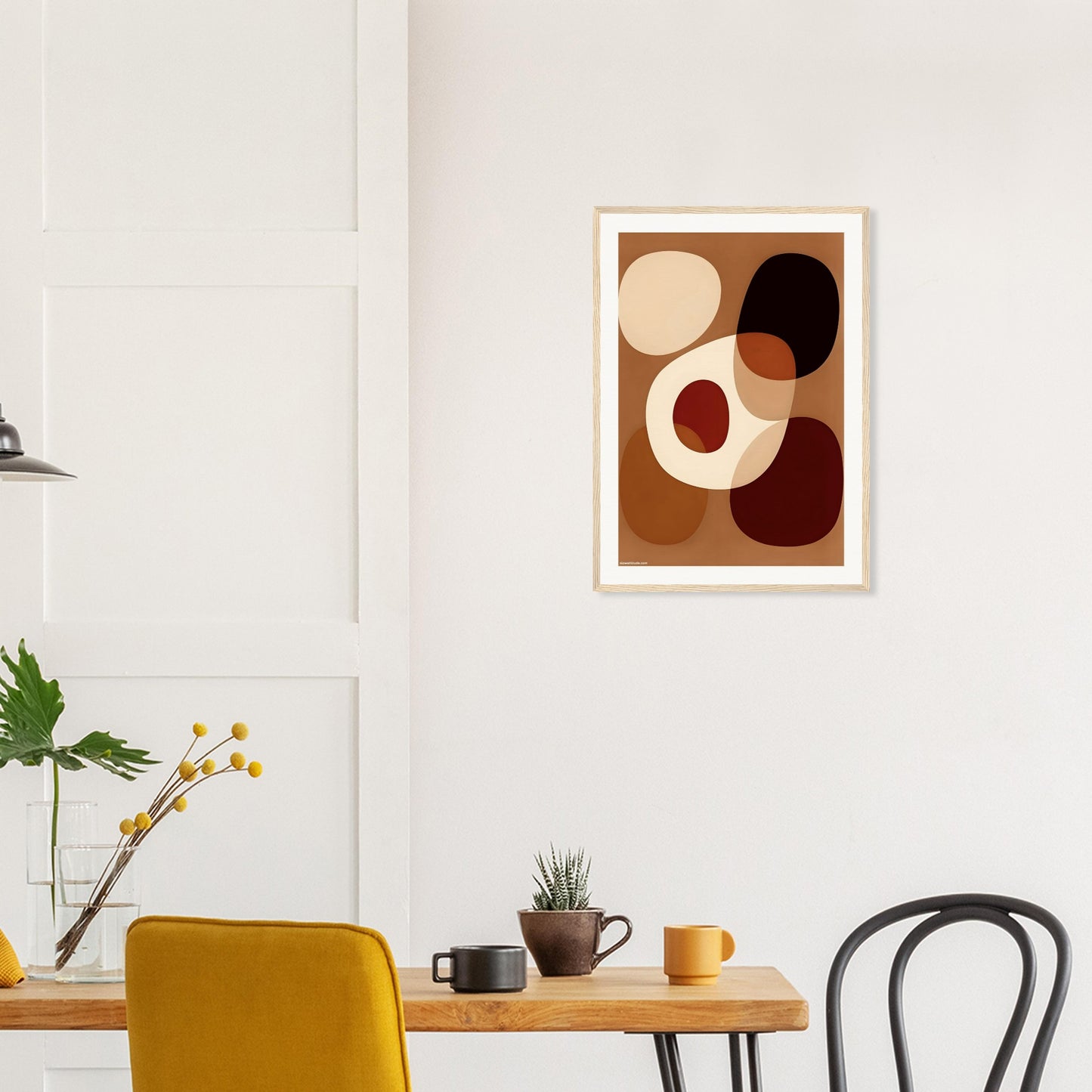 Abstract art print on a wall above a dining table with chairs.