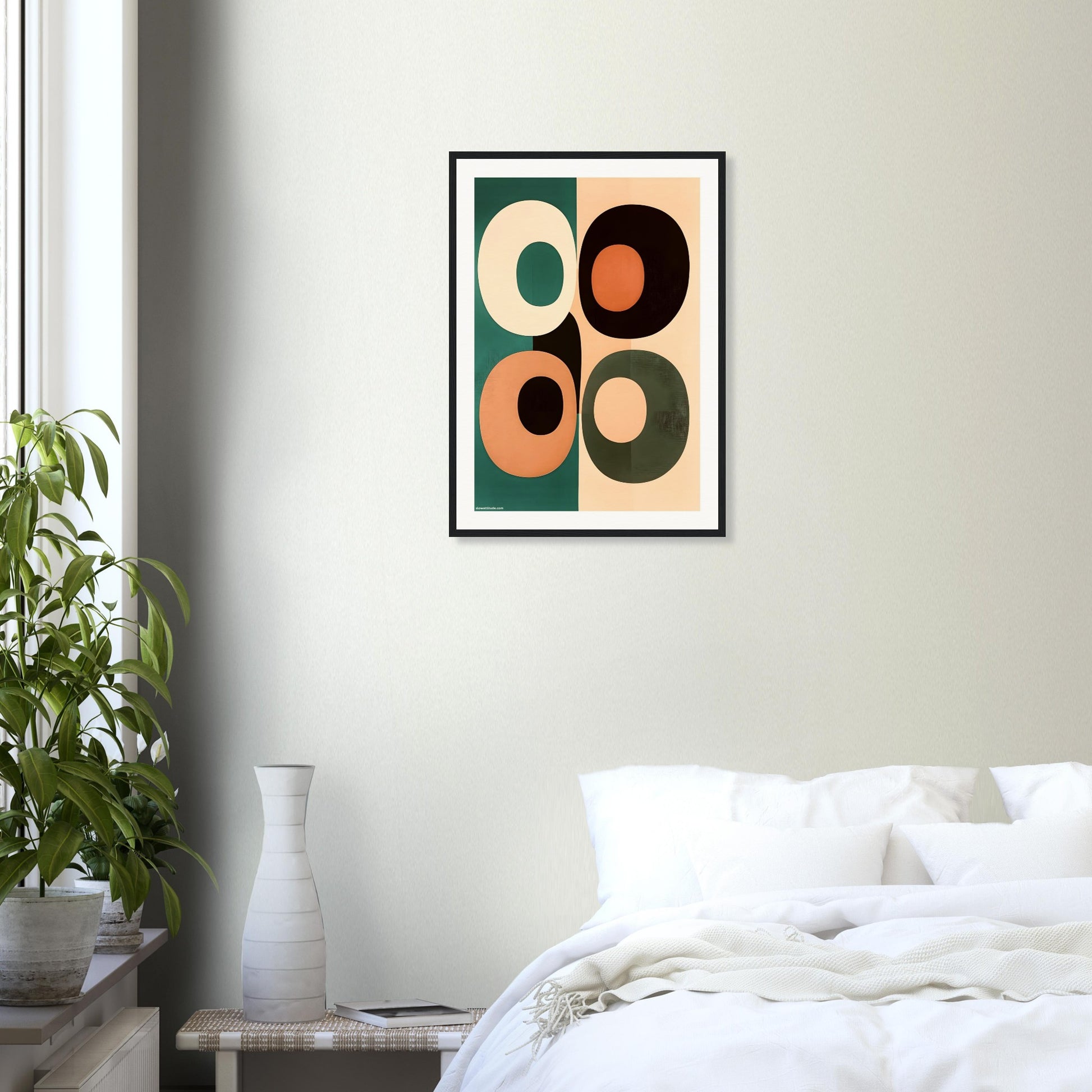 Framed abstract art print on a wall above a bed in a bedroom.