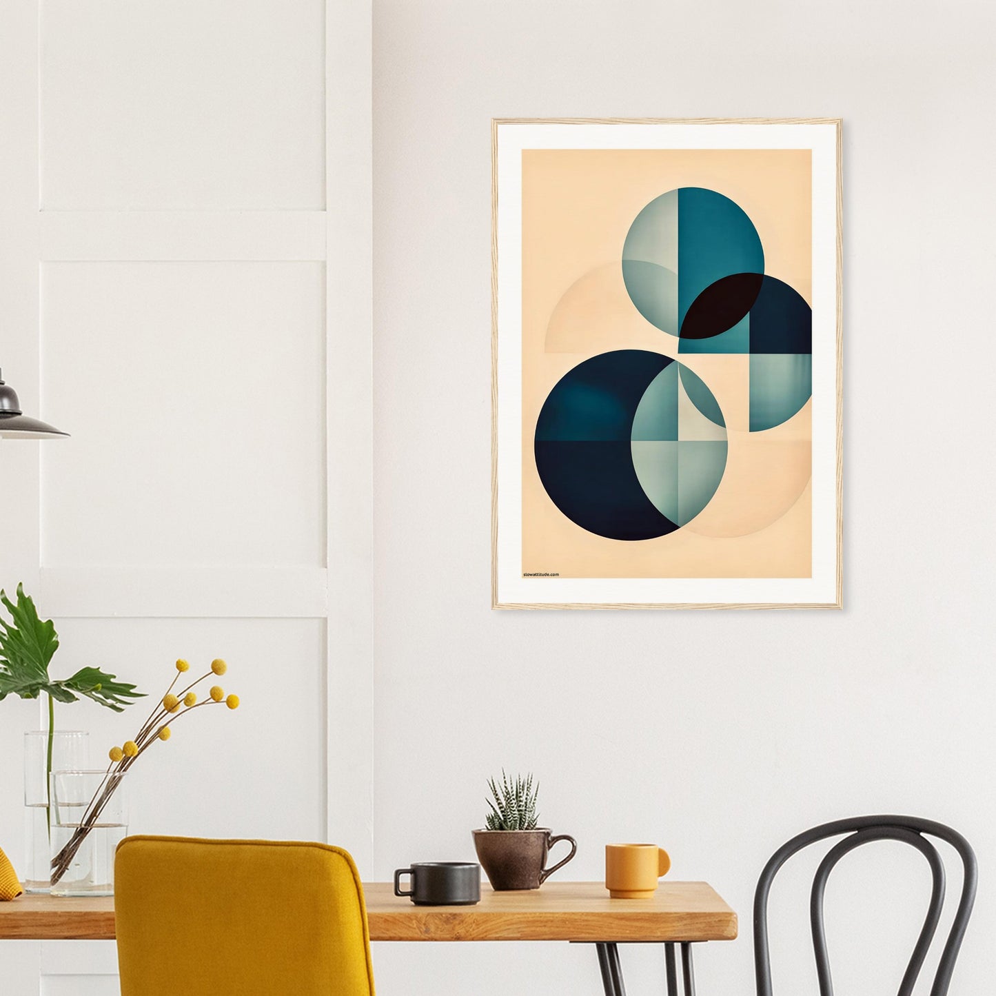 Abstract art print on a wall above a wooden table with chairs.