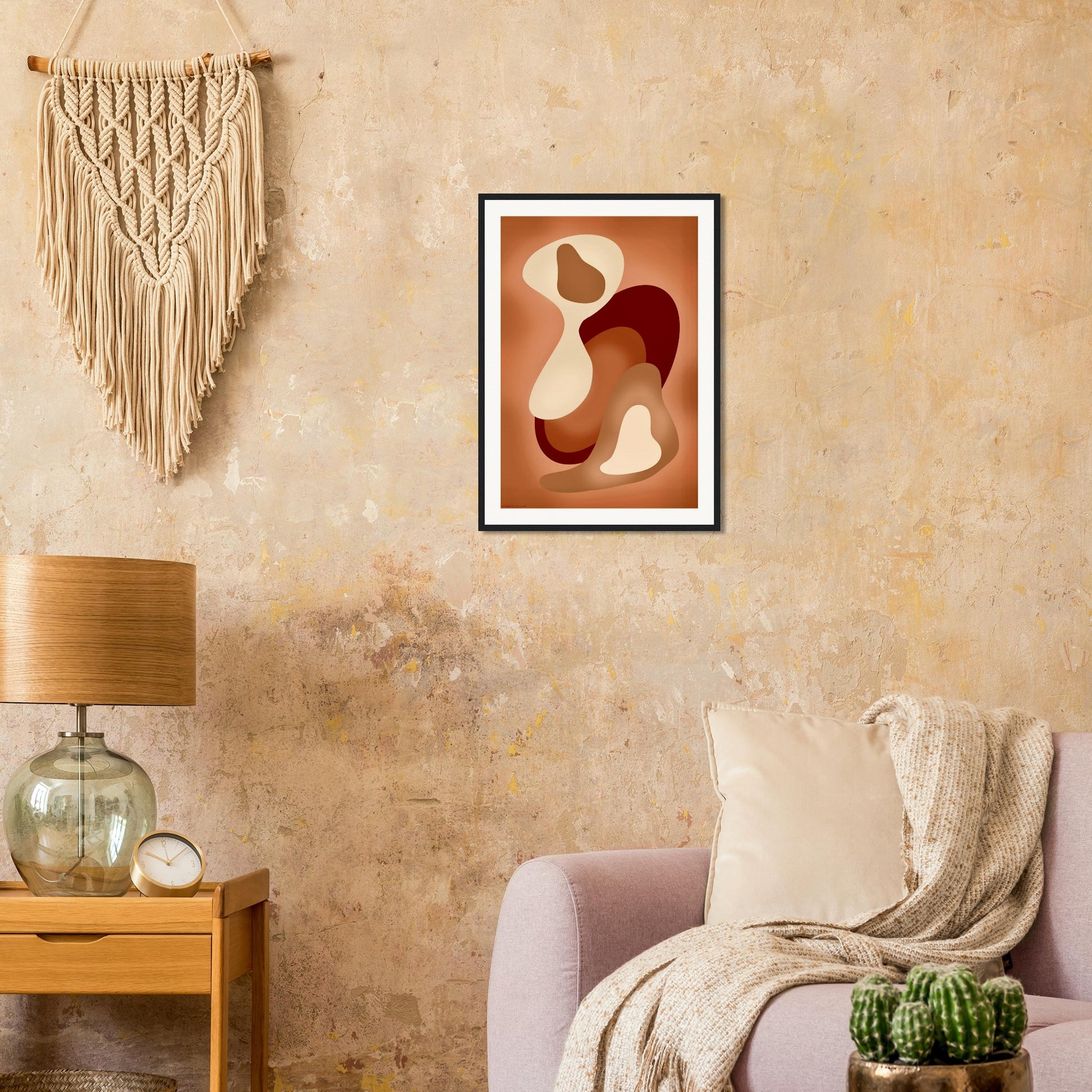 Abstract earth tones framed poster in modern living room with boho decor, black frame and slow living neutral organic shapes.
