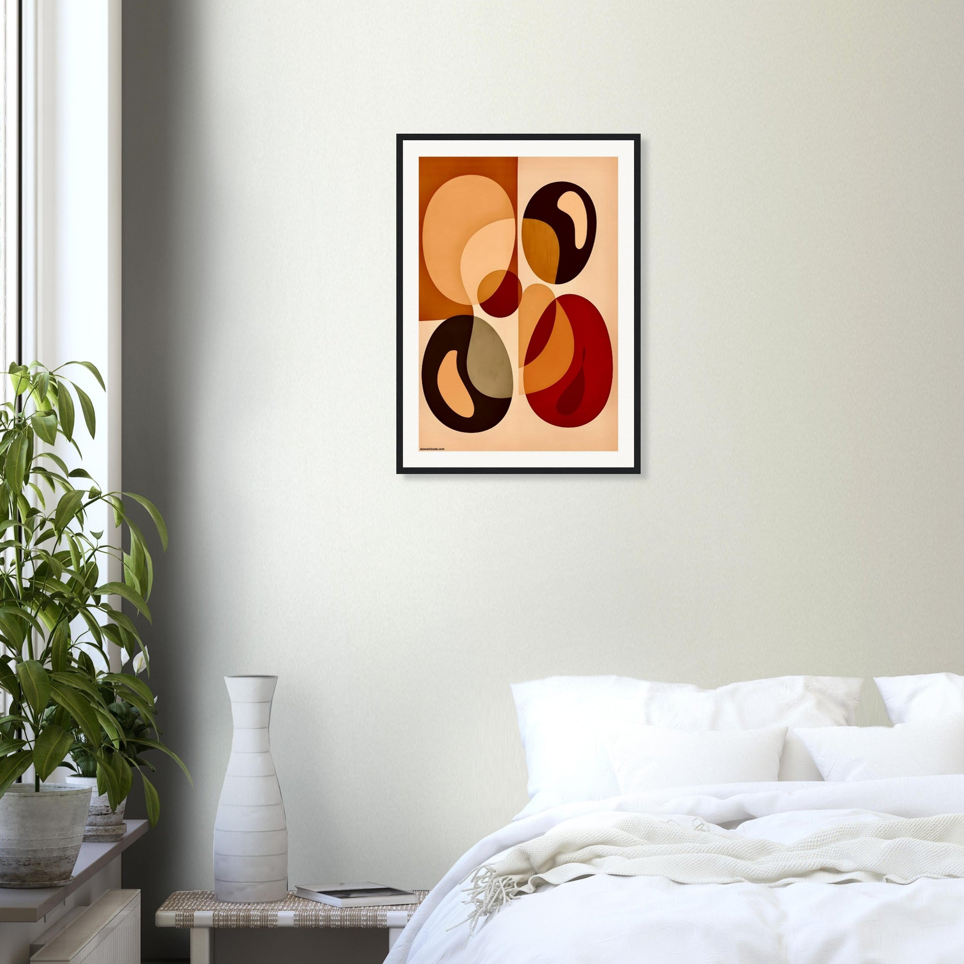 Abstract art print with earth tones in a modern bedroom setting with a plant and bed.