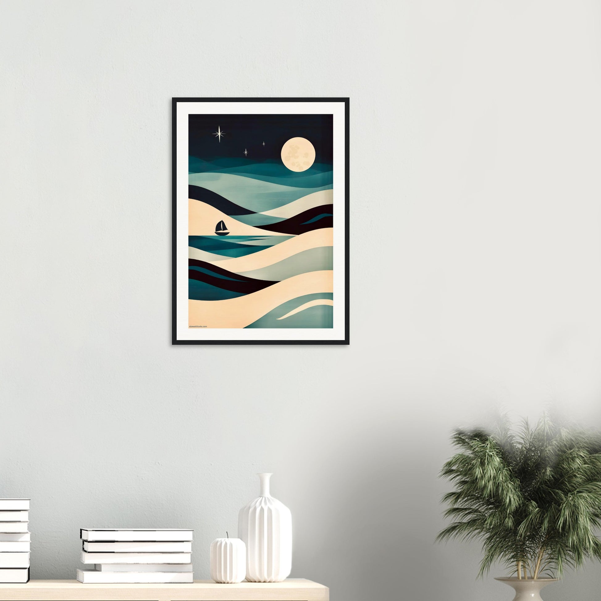 Framed abstract artwork of wavy lines and a moon on a white wall above a shelf with decorative items.